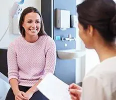 Woman smiling during a medical consultation.