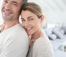 Smiling couple in a bright living room.