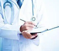 Doctor writing notes on a clipboard.