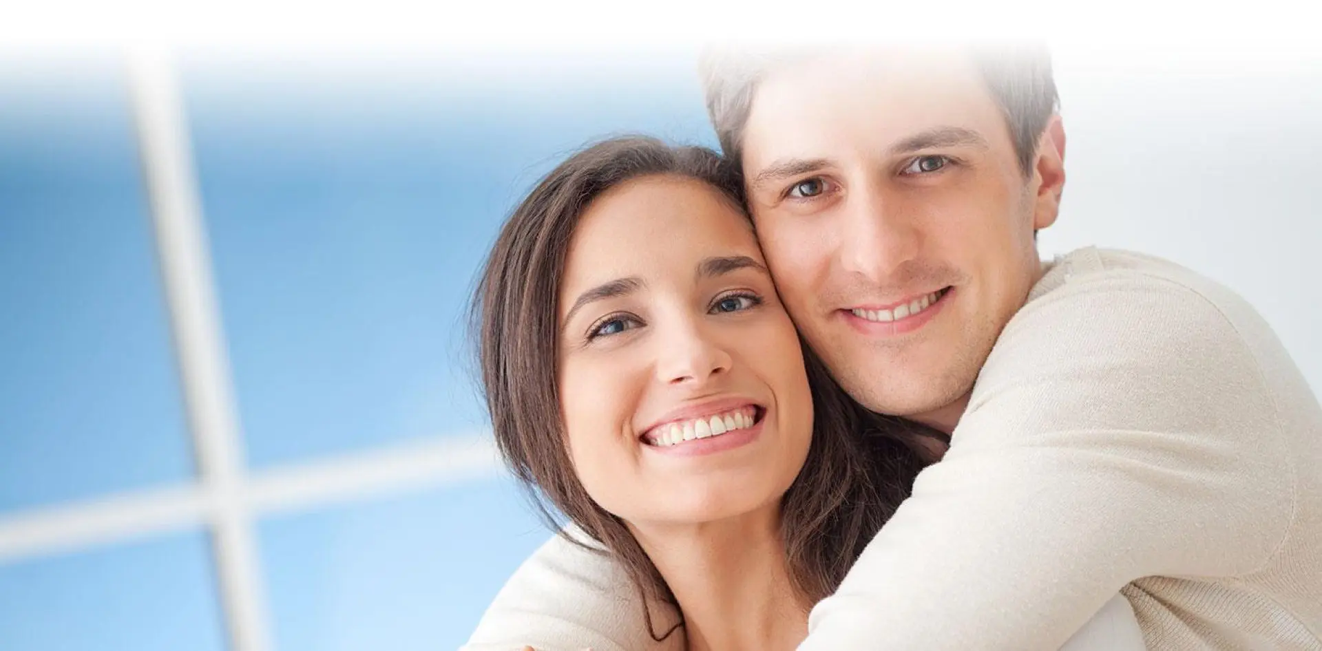 hero 02-1 Smiling couple embracing in bright room.