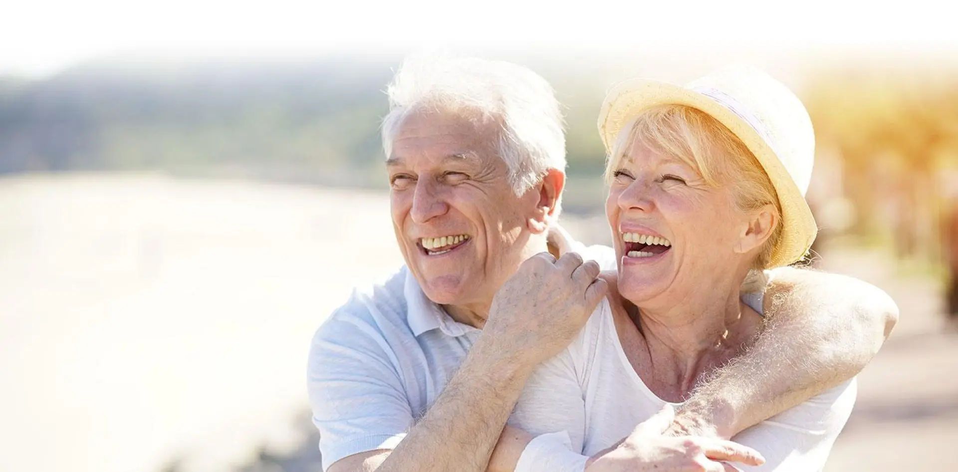hero 03-1 Smiling elderly couple embracing outdoors.
