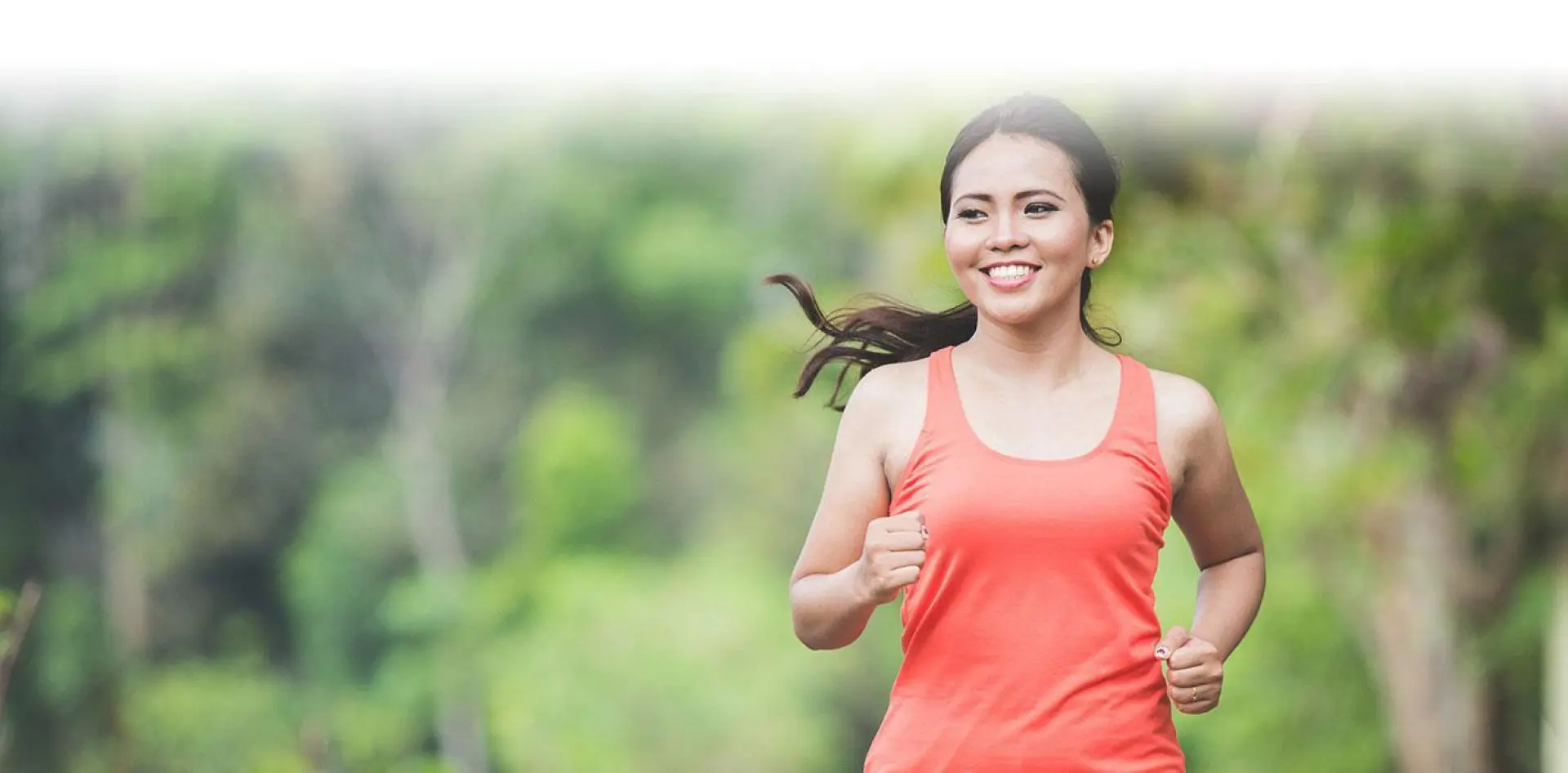 hero 04-1 Smiling woman jogging in a park.